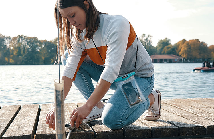 Woman at with a boat at a lake using a dry bag