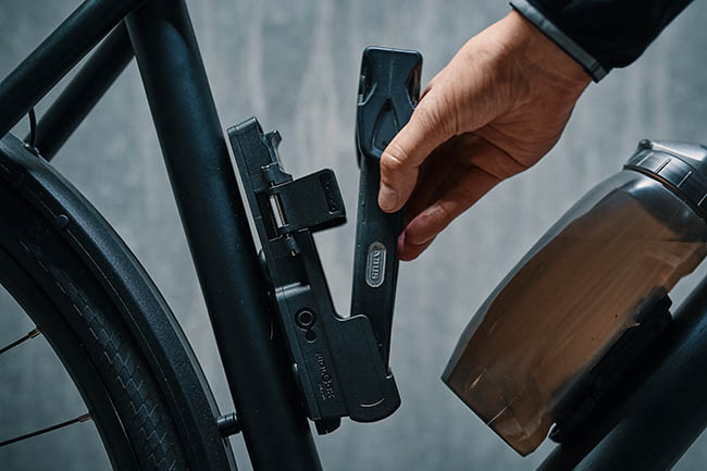 Hand placing a bike lock on the bike frame