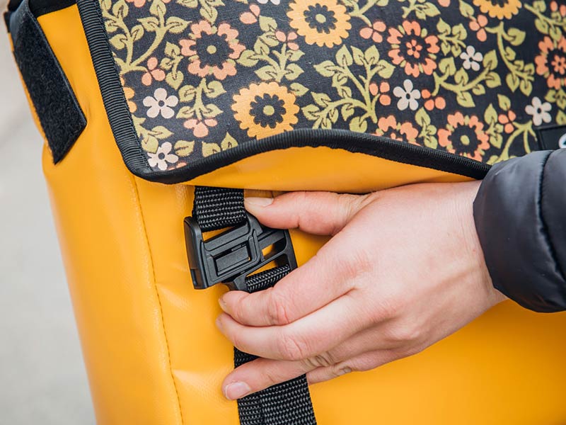 Close-up and use of the SLIDER 25 buckle on the Sarinee messenger bag