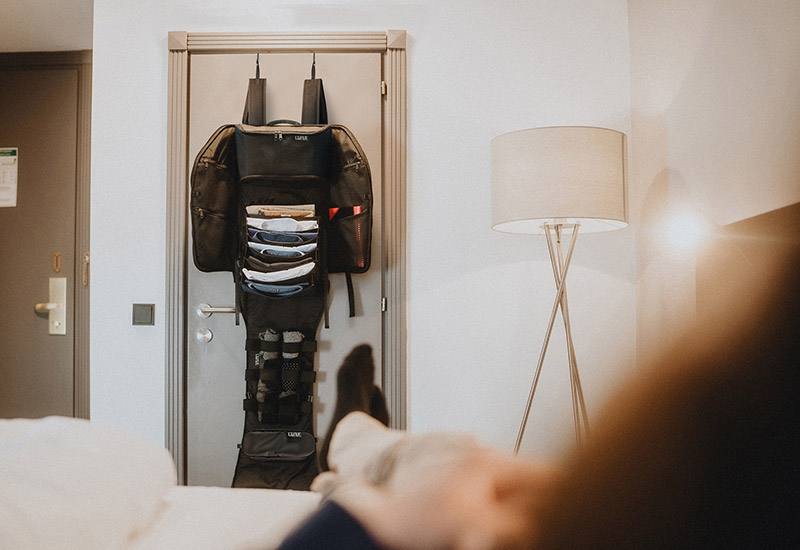 Lifestyle shot of the LiWAVE backpack used in a hotel room
