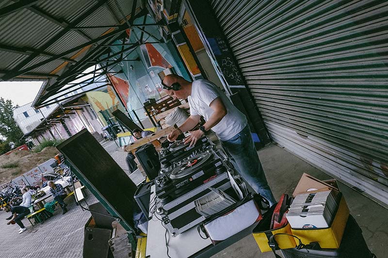 DJ oonops performing at a gig with his equipment in the pannier