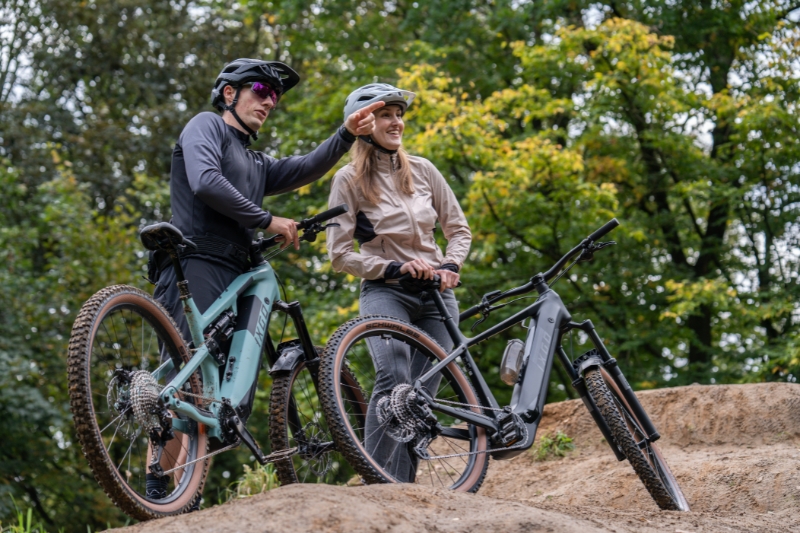 two people standing with IXGO bikes
