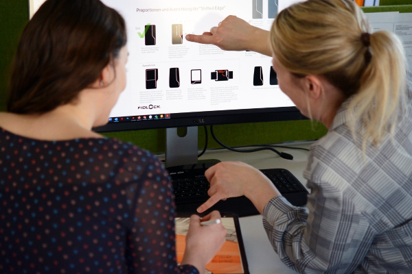 fidlock-custom development-two-women-working-on-a-screen-conception