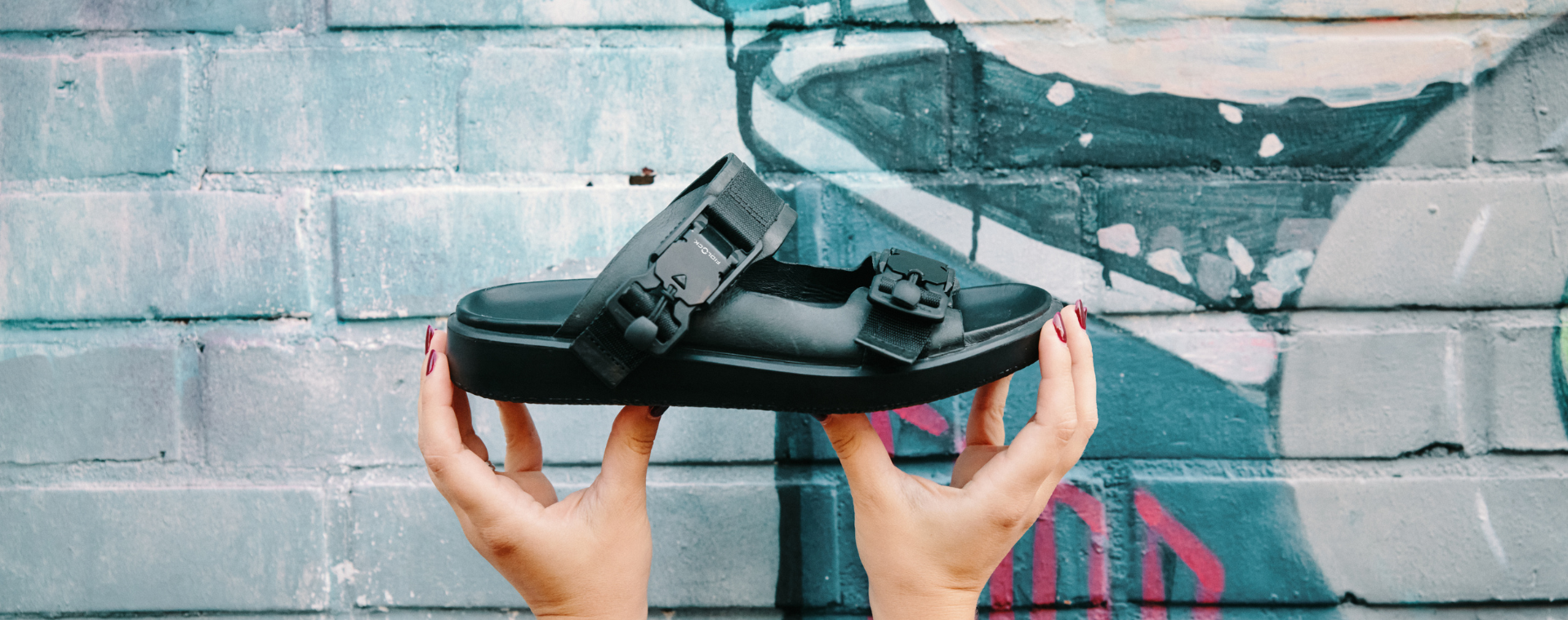 woman holding sandal with FIDLOCK buckles