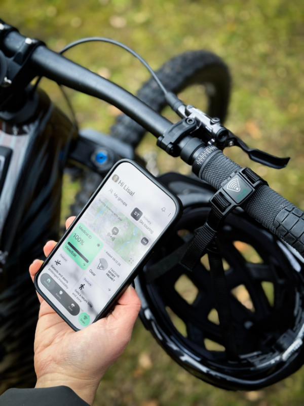 Person holding phone with twiceme App over smart helmet buckle 