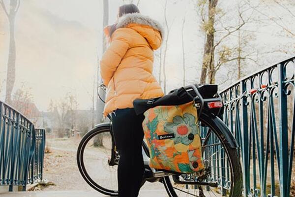 Woman with Sarinee bike backpack attached to bike as preview for the application