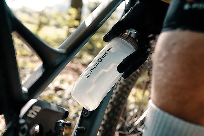 Biker places bottle on his bike frame