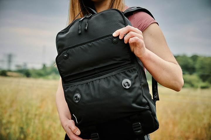 woman opening a backpack with FIDLOCK SNAP fasteners on the flap