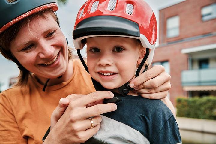 Mother and toddler putting on helmets with FIDLOCK fasteners