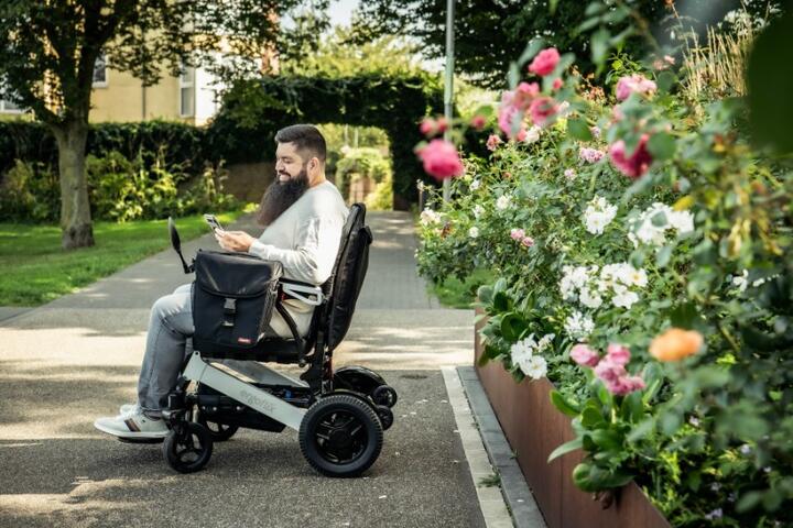 man in wheelchair in rose garden