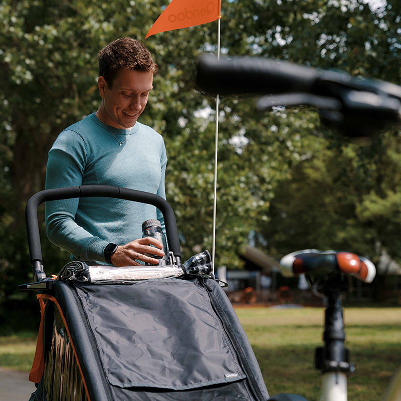 FIDLOCK-TWIST-bottle-700-grau-am-Kinderwagen-Qeridoo-Mann-befestigt-Flasche-am-Kinderwagen