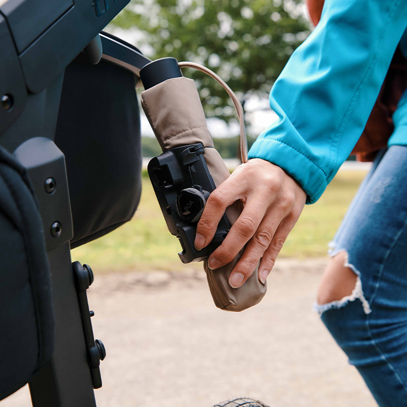 FIDLOCK-TWIST-uni-connector-Frau-befestigt-Regenschirm-am-Kinderwagen