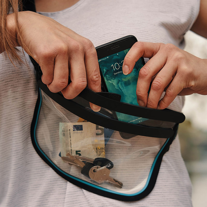 FIDLOCK-HERMETIC-sling-bag-transparent-hände-tun-handy-rein-umgehängt-über-schulter